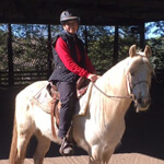 man in red sweater on a white horse